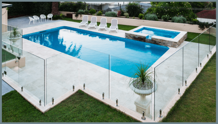 Frameless glass pool fencing around a backyard swimming pool and spa in Canberra, designed for easy cleaning and low maintenance.