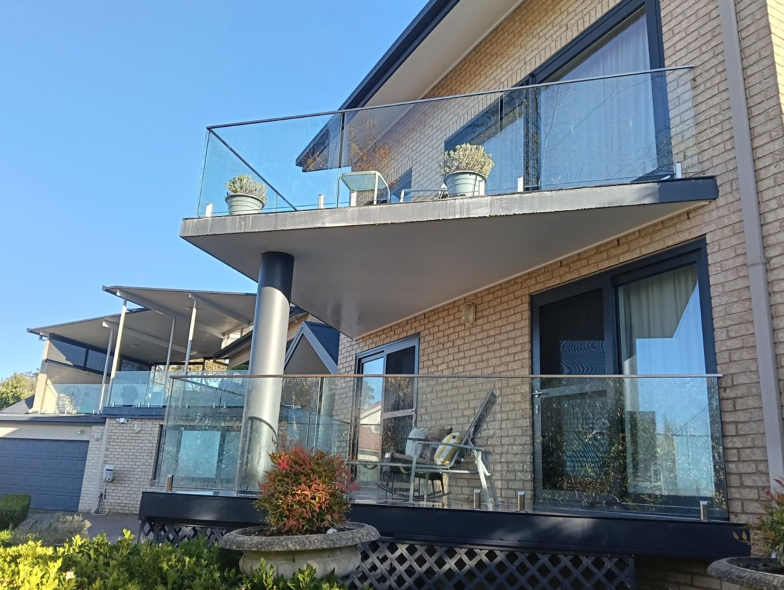 A large brick house with a balcony and a glass railing