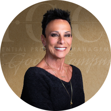 Woman with short, dark hair smiles; wears a black sweater and necklace. Background includes text and a logo.