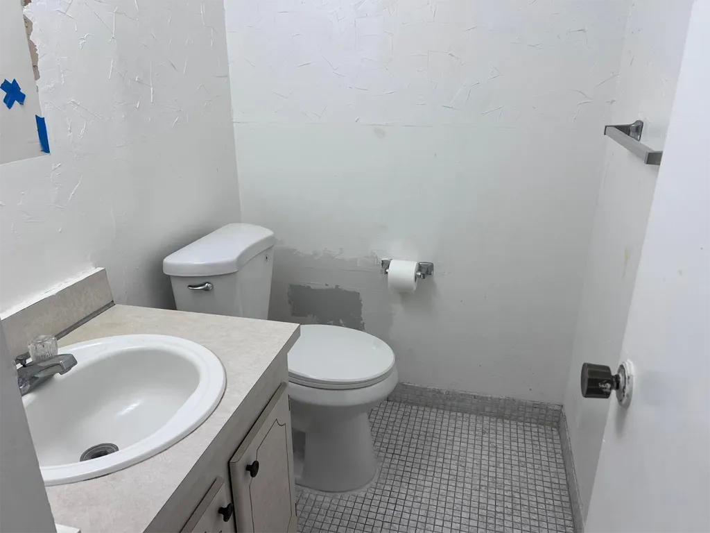 Half bathroom near entrance of Unit 703, Ixora Ct, North Miami, FL 33181.
