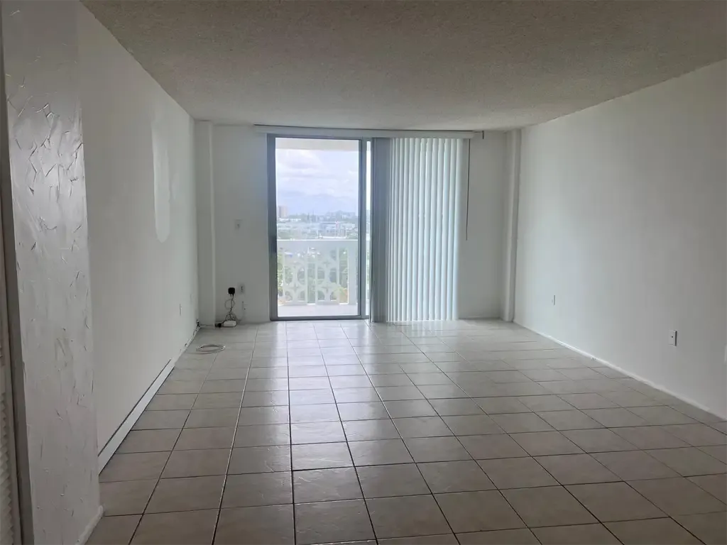 Interior of Unit 703, Ixora Ct, North Miami, FL 33181. Living area toward balcony.