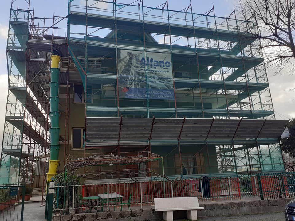 Edificio in costruzione con impalcature, rete di sicurezza verde