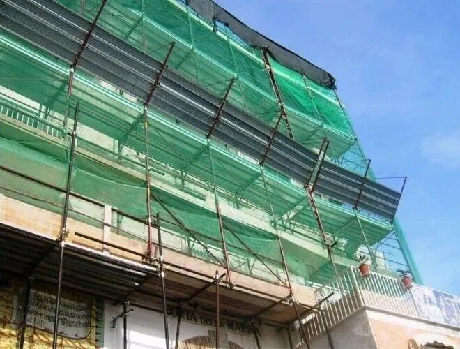 Ponteggi ricoperti da reti di sicurezza verdi