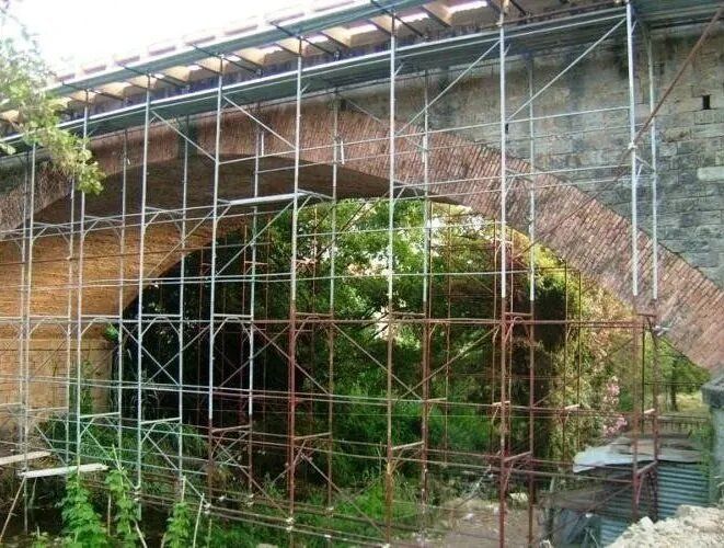 Impalcature attorno a un ponte ad arco in mattoni