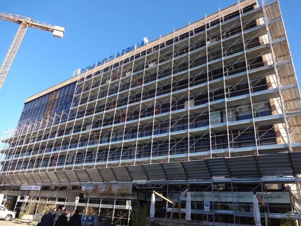 Moderno edificio per uffici a più piani in costruzione, con impalcature e gru