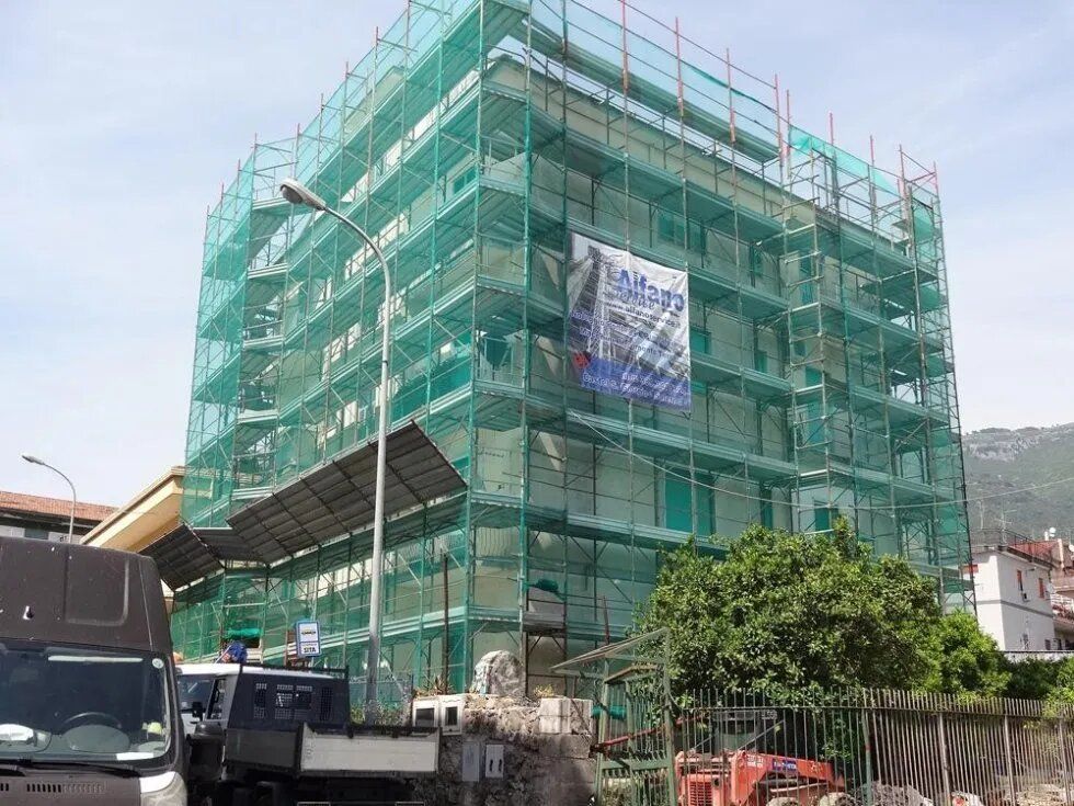 Edificio ricoperto da rete verde in costruzione