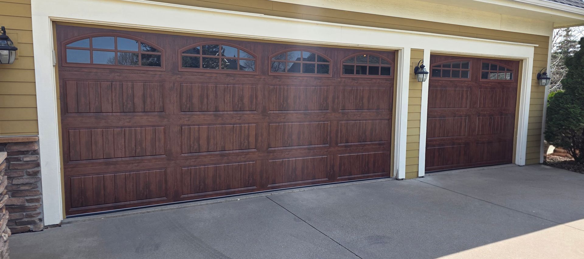 White double garage door on a house exterior beside a concrete driveway.