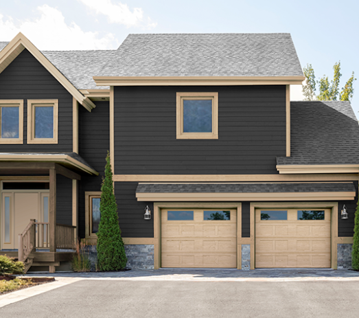 Dark home with two tan Garaga garage doors