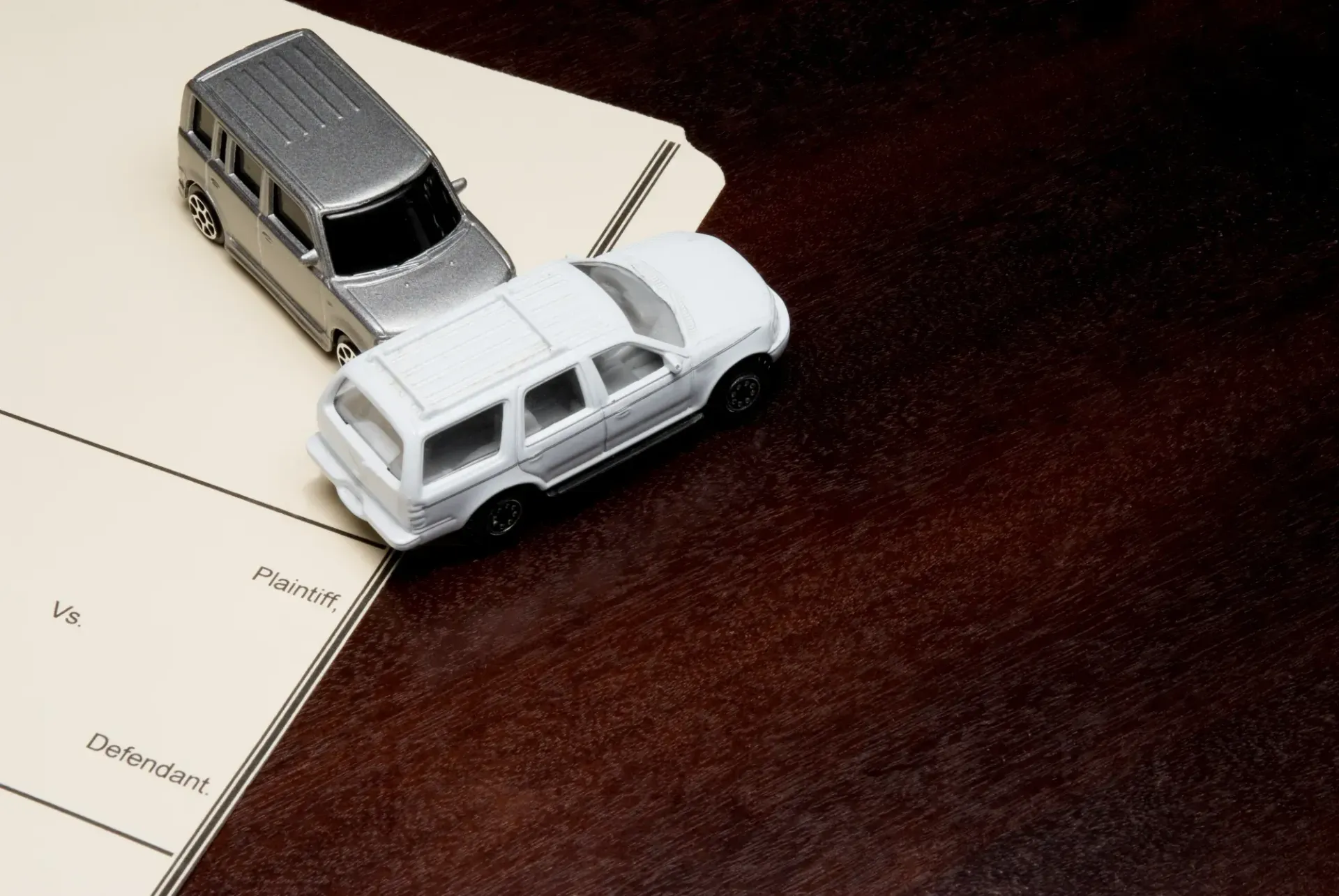 Two Toy Cars on A Paper Surface, One White and One Silver — Queensland Lawyers Cairns In Cairns City, QLD