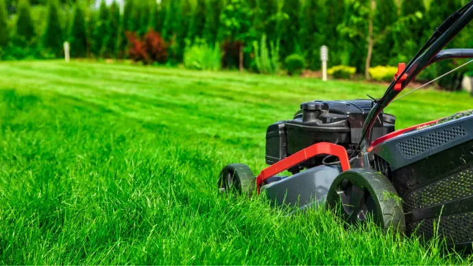 a lawn mower mowing a green lawn