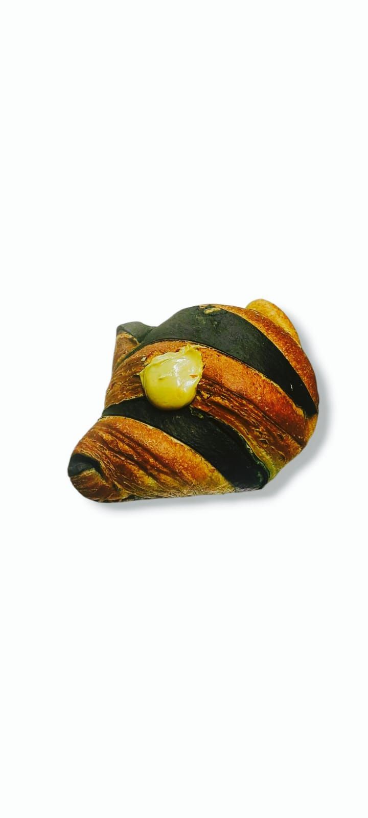 Un dolce con strisce marrone scuro, arancioni e nere, guarnito con un ciuffo giallo.