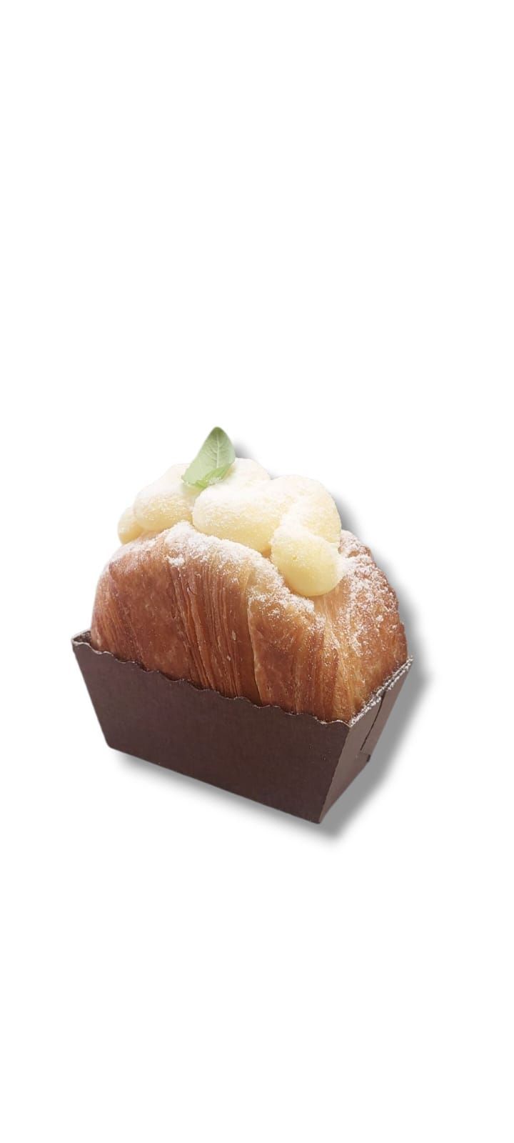 Torta con glassa e una foglia di menta, in un contenitore di carta marrone, su uno sfondo bianco.