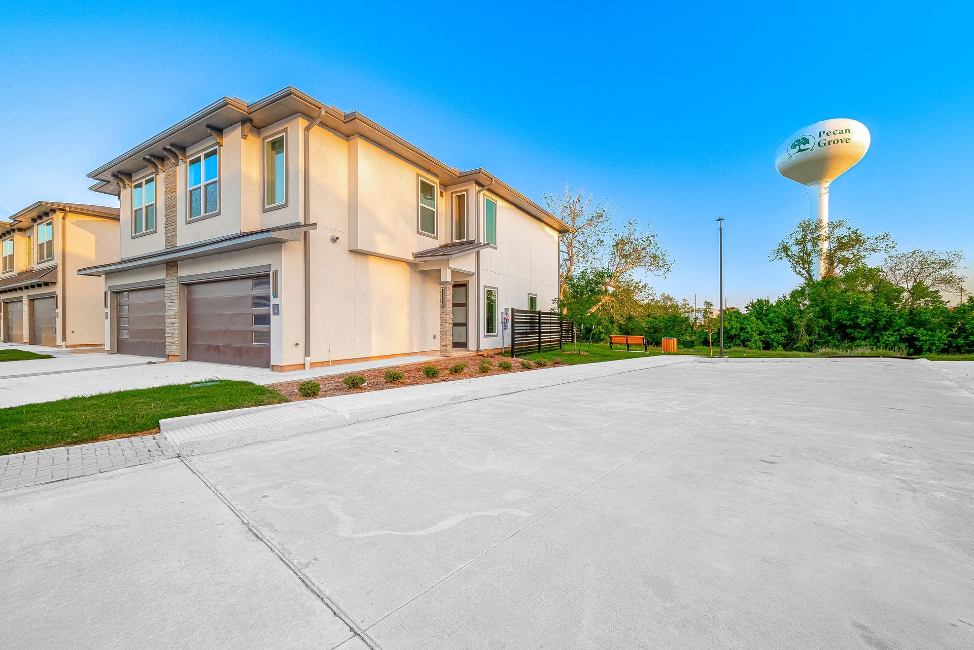 Suburban two-story house with a large driveway and a water tower in the background