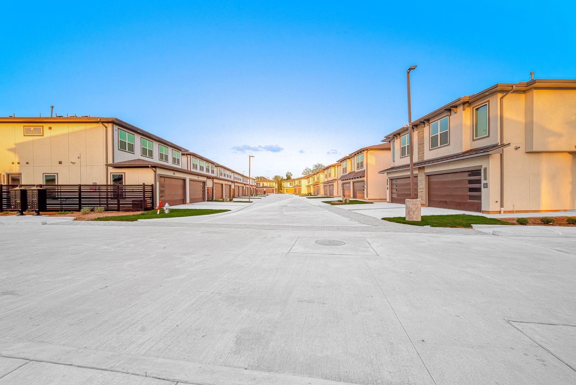 Snowy residential street lined with beige apartment buildings under a clear sky