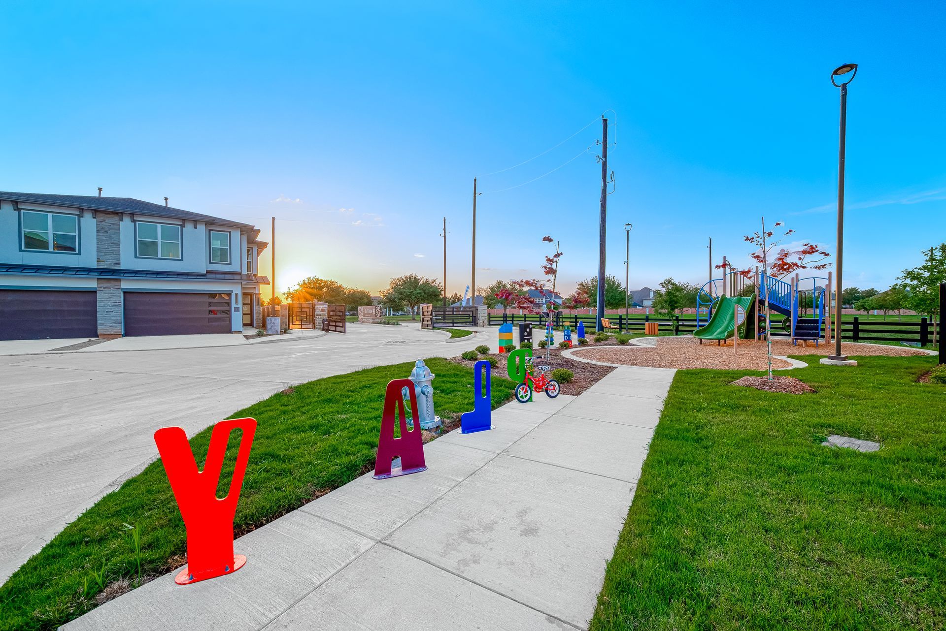 Colorful letters along a sidewalk in a playground park at sunset