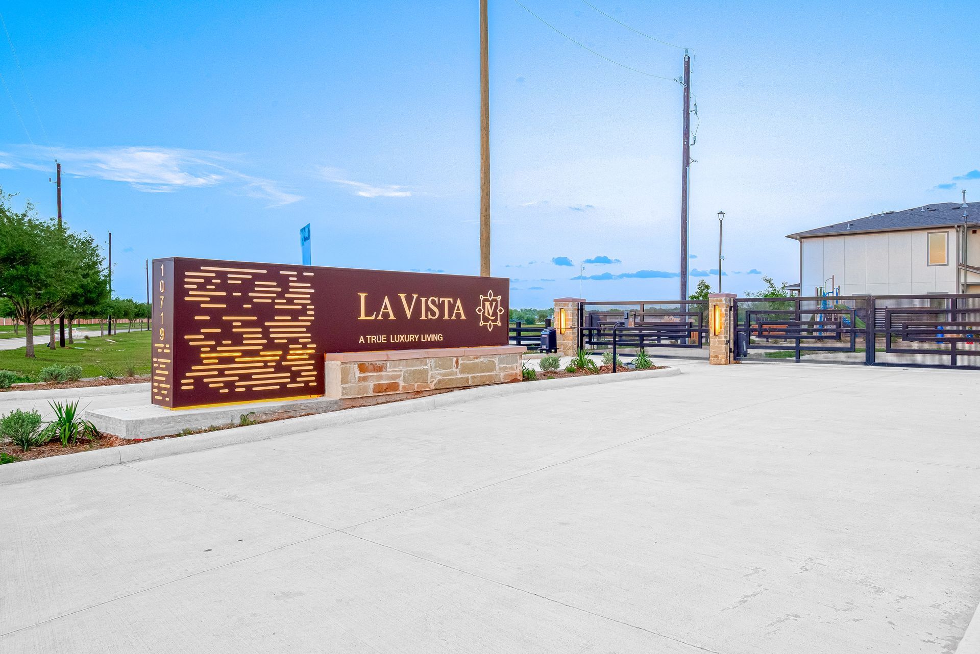 La Vista gated entrance sign beside a paved road under a blue sky