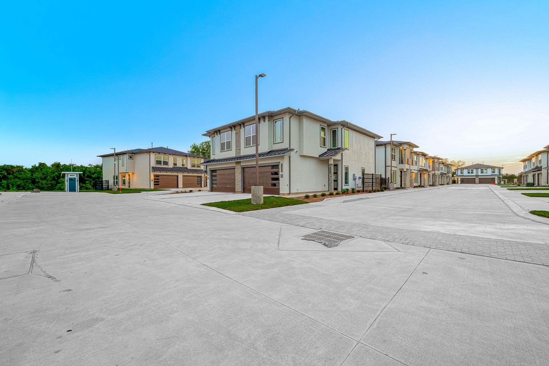 Apartment complex parking lot with beige buildings and a clear blue sky