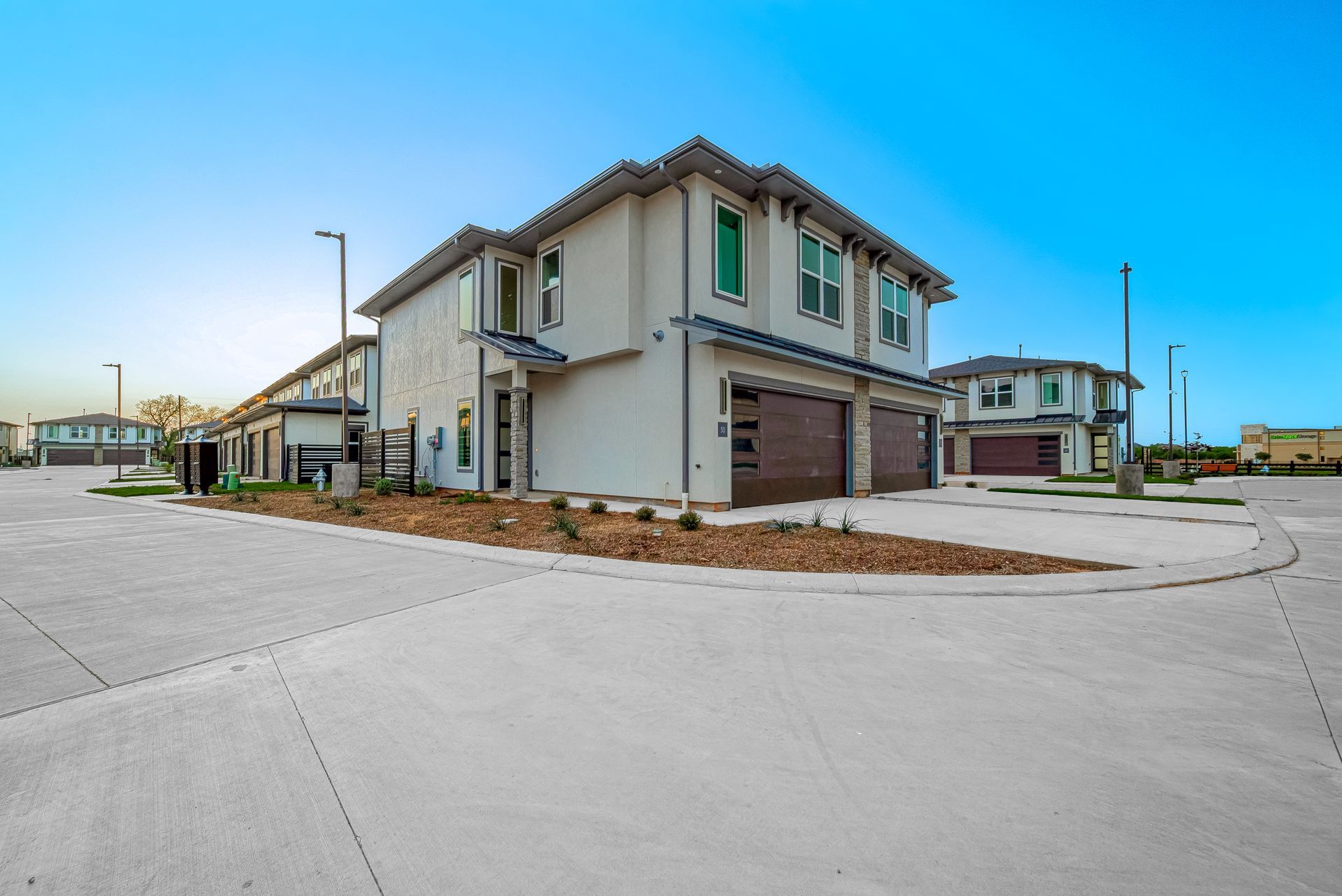 New homes on a quiet suburban street under a clear blue sky