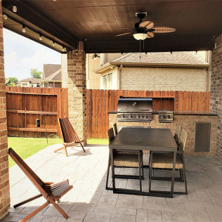 Covered patio with a dining set, grill, and lounge chairs.