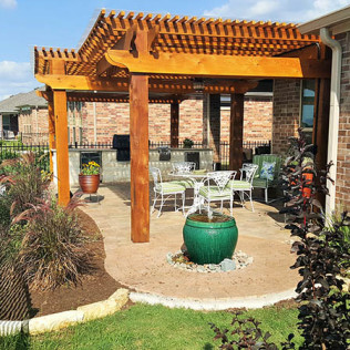 Outdoor patio with wooden pergola, seating, fountain, and built-in grill area.