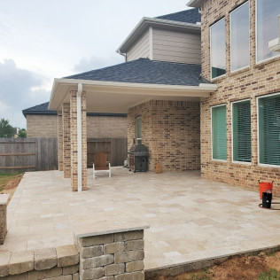 Brick patio with a covered outdoor area attached to a brick house.