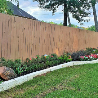 Wooden fence with landscaping and lawn.