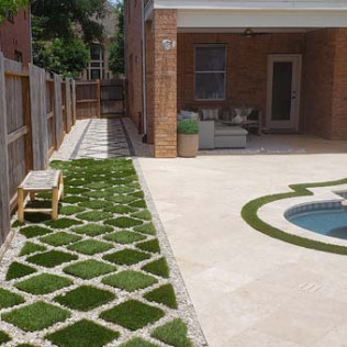 Backyard with diamond-patterned grass path, patio, pool, and brick house.
