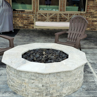 Stone fire pit with brown Adirondack chair, a covered grill, and a swing on a brick patio.