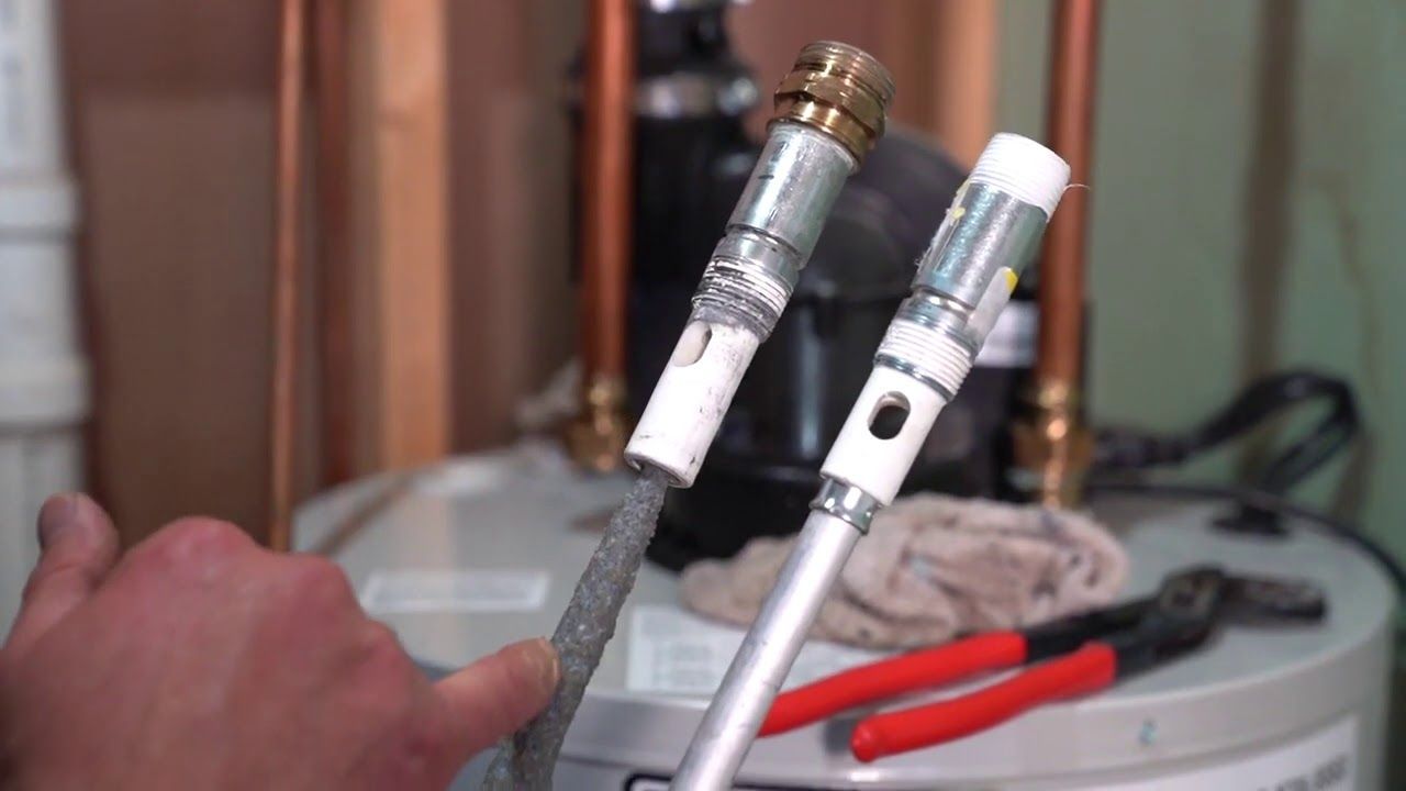 A person is fixing a water heater with a pair of pliers. Northglenn, Colorado accountable home services