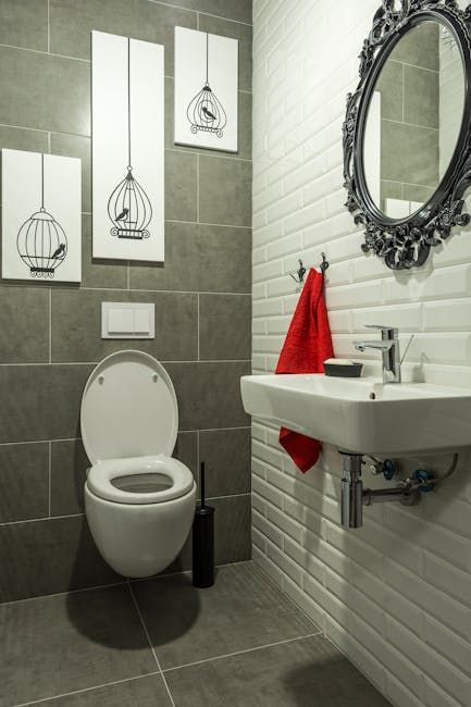 Modern bathroom with white toilet, sink and mirror in Denver home