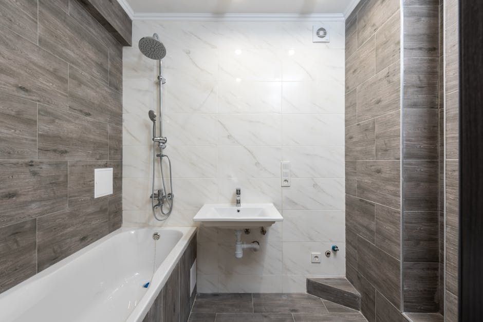 Modern bathroom shower with white tiles and glass door in Denver home