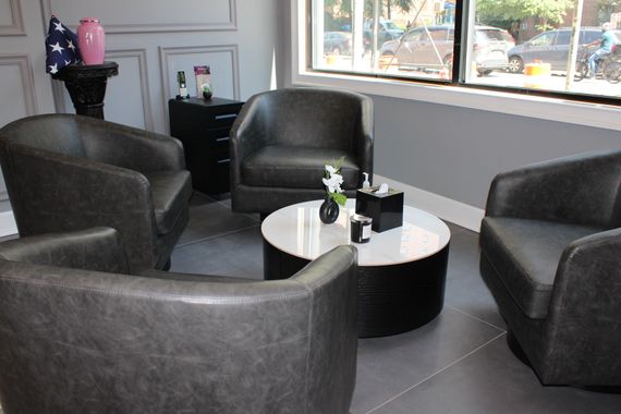 Eastside Funeral chapel waiting and meeting Modern lounge with four black armchairs around a round coffee table near windows