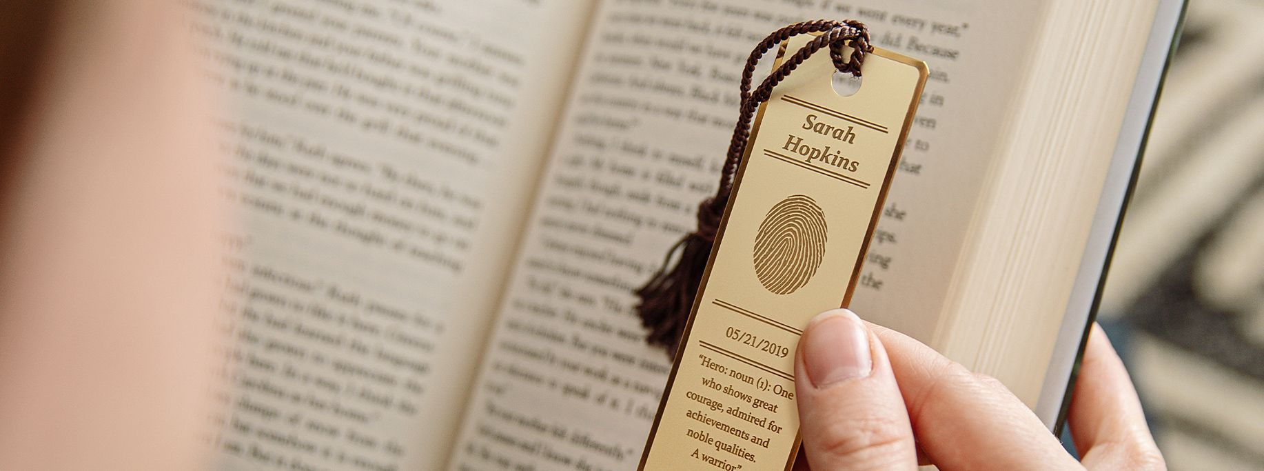 International Funeral Service Southview Trenton NJ - Hand holding a bookmarked open book with a tan tag against beige pages.