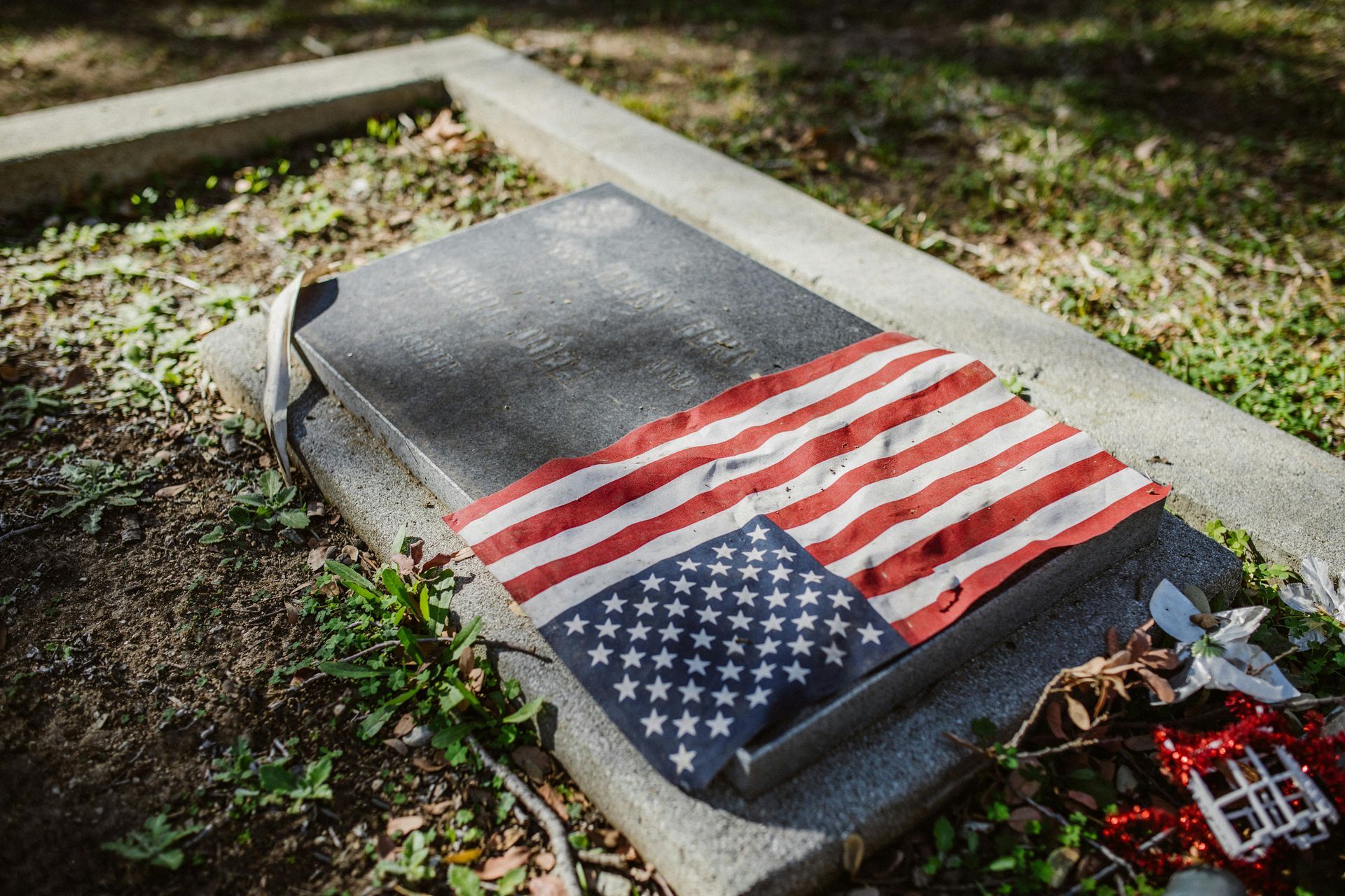 Gravestone covered with an American flag in a cemetery