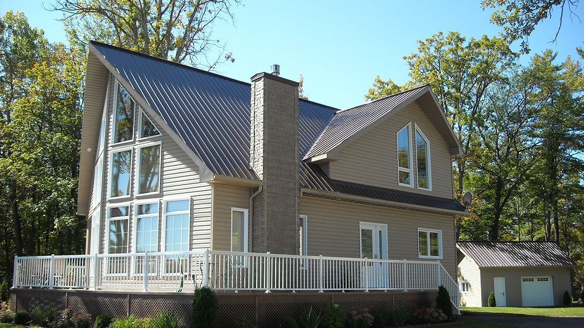 Beige two-story house with a metal roof