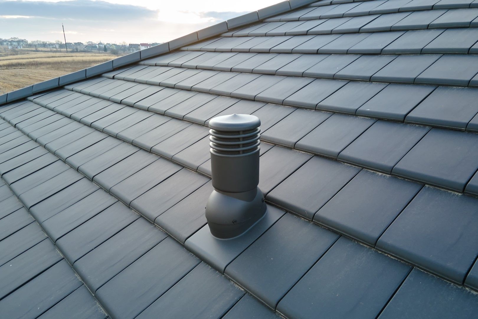 Dark gray tiled roof with a dark gray vent