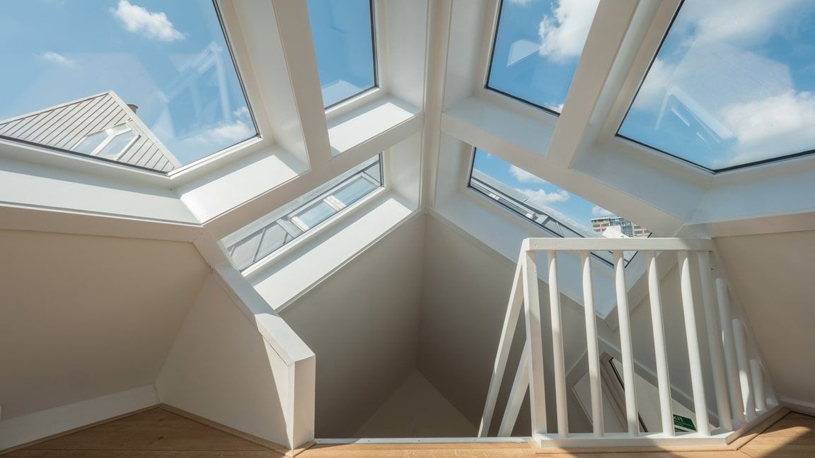 Bright attic interior with skylights, white beams