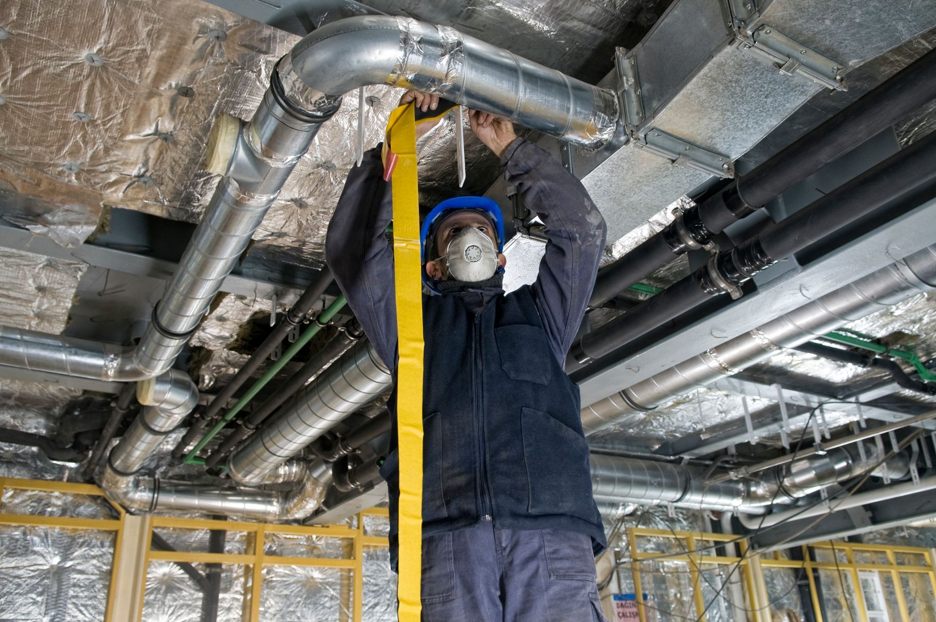 A man is measuring a pipe with a tape measure.