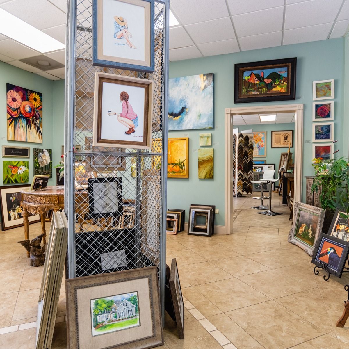 Art gallery interior with colorful framed paintings displayed on walls and stands