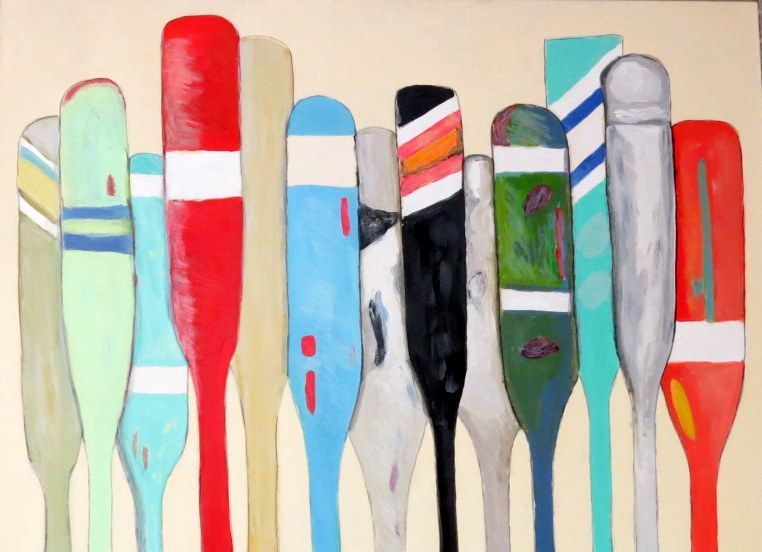 Colorful painted broom and brush handles standing upright in a row against a light background.