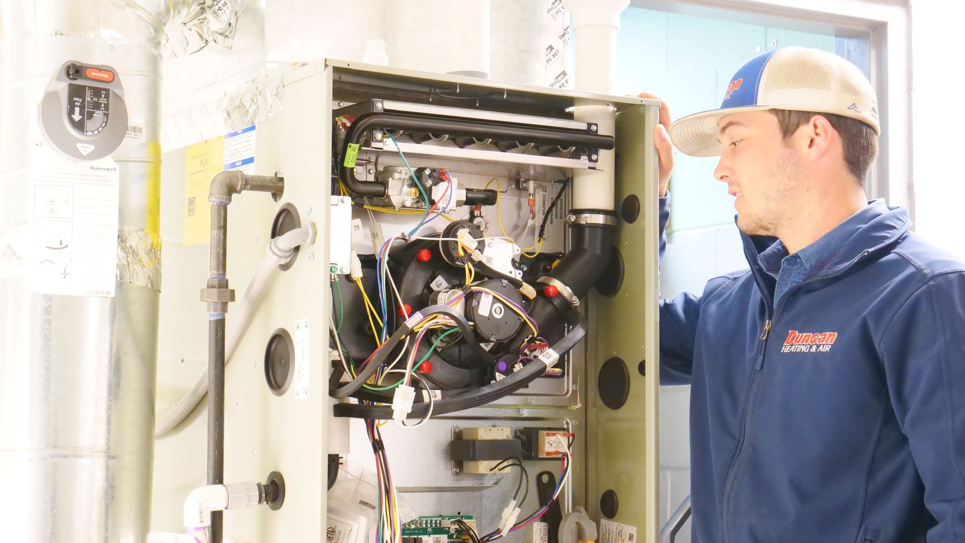 A man in a blue jacket is working on a machine.