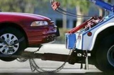 Tow truck towing away and broken down car