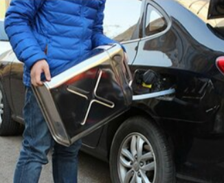 Picture of a person pouring fuel in a vehicle with a jerry can.