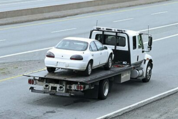 Towing Coquitlam white flatbed tow truck towing a white car.