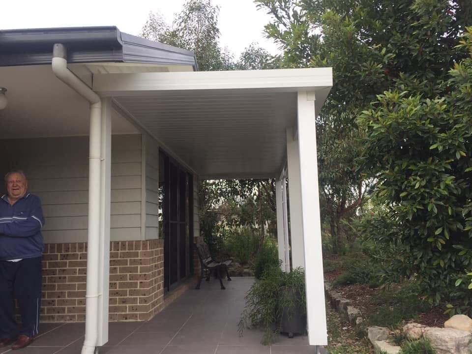 A man is standing on the porch of a house.
