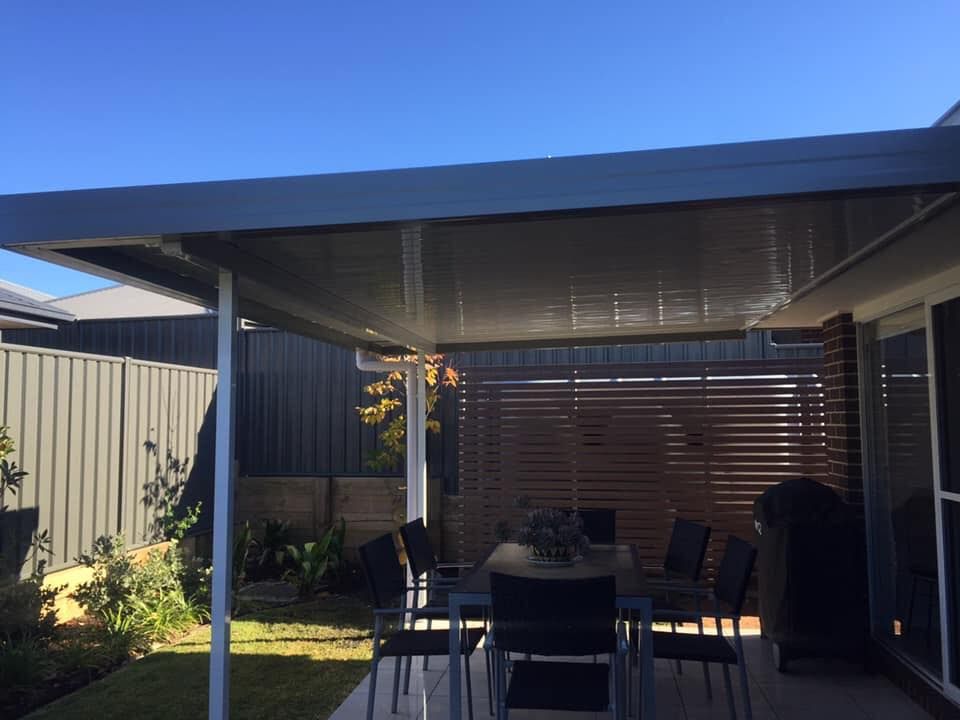 A patio with a table and chairs under a canopy.