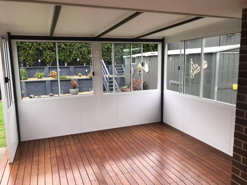 An empty room with a wooden floor and a lot of windows.