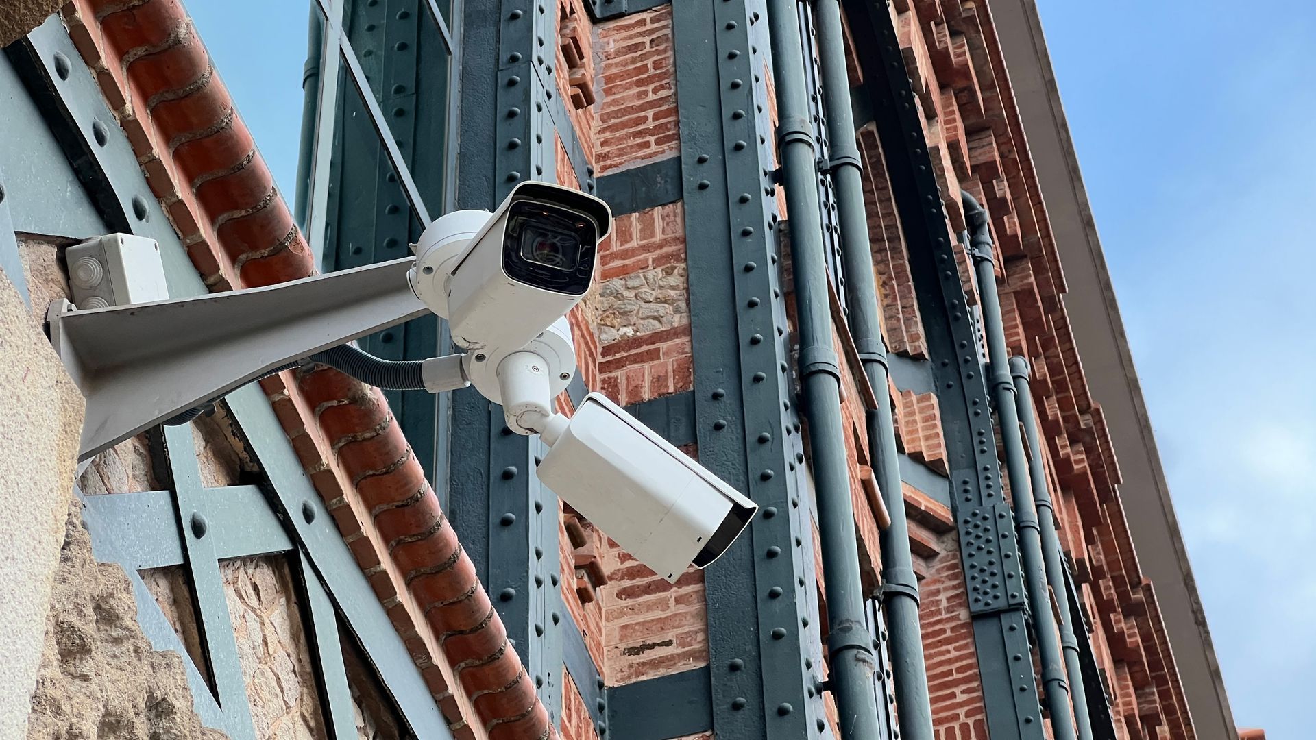 A security camera is mounted on the side of a building.