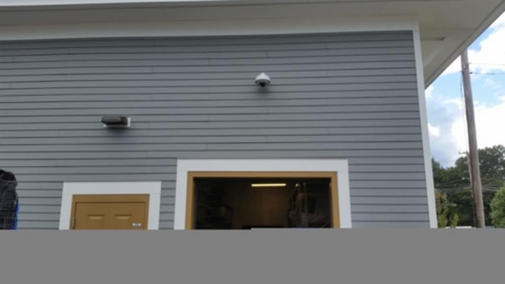 A garage door is open on the side of a house.