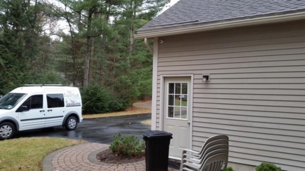 A white van is parked in front of a house.